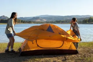 Young women setting up their tent next to a 