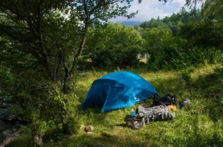 Blue tent set up in a countryside landscape
