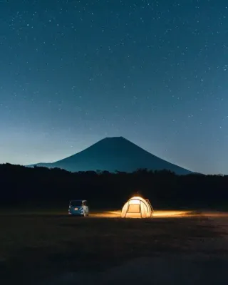 Bivouac at night in Japan with Mount Fuji standing out from the sky in the distance